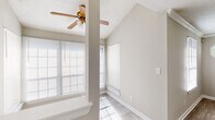 This single-story, 2-bedroom, 2-bathroom home in Union City, Georgia offers a functional and comfortable layout across a well-utilized floor plan. The living room features vaulted ceilings that create an airy sense of space, complemented by a ceiling fan and multiple windows that flood the room with natural light. Wood-look tile flooring runs through the main living areas, adding a clean, modern aesthetic. A charming octagonal accent window and crown molding add character to the dining room, which also features the same light-toned flooring. The kitchen is equipped with warm oak cabinetry, ample counter space, a double-basin stainless steel sink, and a gas range, making it both practical and inviting. The primary bedroom is generously sized, featuring plush carpet, dual windows, and a ceiling fan, along with access to a walk-in closet fitted with wire shelving. The second bedroom similarly offers carpet flooring and a ceiling fan. Both bathrooms are neatly appointed, with one featuring a full tub-shower combination and wood-look flooring. Three closets throughout the home provide ample storage. The textured ceilings and neutral color palette throughout create a cohesive, move-in-ready atmosphere.