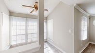 This single-story, 2-bedroom, 2-bathroom home in Union City, Georgia offers a functional and comfortable layout across a well-utilized floor plan. The living room features vaulted ceilings that create an airy sense of space, complemented by a ceiling fan and multiple windows that flood the room with natural light. Wood-look tile flooring runs through the main living areas, adding a clean, modern aesthetic. A charming octagonal accent window and crown molding add character to the dining room, which also features the same light-toned flooring. The kitchen is equipped with warm oak cabinetry, ample counter space, a double-basin stainless steel sink, and a gas range, making it both practical and inviting. The primary bedroom is generously sized, featuring plush carpet, dual windows, and a ceiling fan, along with access to a walk-in closet fitted with wire shelving. The second bedroom similarly offers carpet flooring and a ceiling fan. Both bathrooms are neatly appointed, with one featuring a full tub-shower combination and wood-look flooring. Three closets throughout the home provide ample storage. The textured ceilings and neutral color palette throughout create a cohesive, move-in-ready atmosphere.