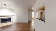 Located at 6142 Bonita Rd, Unit M205, in Lake Oswego, Oregon, this 1-bedroom, 1-bathroom apartment offers 540 square feet of thoughtfully laid-out single-floor living space. The open living room is a standout area, featuring warm wood-look laminate flooring, a tile-surround fireplace with a classic mantel, and a sliding glass door that welcomes abundant natural light and provides access to an outdoor area. Track lighting overhead adds a functional and modern touch to the space. The galley-style kitchen is efficiently designed with light maple cabinetry, dark granite countertops, a double stainless steel sink, a dishwasher, and stainless steel appliances including a range and refrigerator, all set atop matching wood-look flooring. The bedroom spans 150 square feet and is finished with plush gray carpet, a natural light-filled window with outdoor views, and a built-in closet with double hanging rods. The bathroom continues the wood-look flooring theme and includes a grab bar and a soaking tub. Clean white walls and crisp trim throughout the unit create a bright, neutral aesthetic.