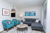 Located at 6885 S Redwood Rd in West Jordan, Utah, this one-bedroom, one-bathroom unit offers a well-designed single-floor layout that maximizes every inch of its space. The living room features rich, dark hardwood-style flooring and a warm, neutral color palette, creating an inviting atmosphere. A decorative arched niche adds a charming architectural detail, while natural light filters in through a window dressed with blinds and curtains. The kitchen connects seamlessly to the living area and is outfitted with crisp white shaker-style cabinetry, granite-style countertops, black appliances including a refrigerator and electric range, and light wood-look flooring—offering both style and functionality. The bedroom is generously sized with plush carpeting, a large window that fills the room with natural light, and direct access to a spacious walk-in closet with built-in shelving and hanging rods. The full bathroom features a combined tub and shower, a vanity with granite-style countertops, white cabinetry, and wood-look flooring, completing the unit with practical elegance. Overall, the space presents a clean, modern aesthetic suited for comfortable everyday living.