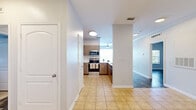 Located at 5215 Millenia Boulevard in Orlando, FL, this well-appointed 2-bedroom, 2-bathroom residence offers a thoughtfully designed single-floor layout with a bright, open feel throughout. The combined living, dining, and kitchen area serves as the heart of the home, featuring wood-look flooring, crown molding, and ceiling fans for comfort. The kitchen is equipped with stainless steel appliances including a range, microwave, and dishwasher, complemented by warm wood-toned cabinetry, a tile floor, and a pass-through counter with a built-in sink — ideal for casual dining or entertaining. The spacious living room opens directly to a private balcony, which overlooks a resort-style pool surrounded by lush palm trees and tropical landscaping. Both bedrooms are generously sized with wood-look flooring and ceiling fans, while the primary bedroom features direct access to its en-suite bathroom, which includes a walk-in shower and a vanity. Six closets are distributed throughout the unit, providing exceptional storage. A dedicated laundry area and pantry add further convenience. The neutral color palette and recessed lighting create a clean, modern ambiance throughout this well-organized Orlando residence.