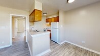 Located at 2110 Popps Ferry Rd in Biloxi, Mississippi, this 2-bedroom, 1-bathroom unit offers a practical and comfortable single-story layout. The open-concept living and kitchen area creates a welcoming central space, complete with a peninsula breakfast bar, warm honey-toned wood cabinetry, white appliances including a refrigerator and electric range, and ample counter space. A textured ceiling and ceiling fan with integrated lighting add character to the living area.

Both bedrooms feature the same durable wood-look plank flooring found throughout the unit, ceiling fans, neutral beige walls, and natural light from large windows fitted with blinds. The primary bedroom includes a sliding-door closet for convenient storage. Hallways connect the rooms efficiently, contributing to a functional flow across the floor plan.

The bathroom is clean and straightforward, featuring a tiled shower-tub combination, a wall-mounted mirror, and a white vanity with a single sink. Consistent neutral tones and white trim throughout the unit create a cohesive, move-in-ready aesthetic. The overall design prioritizes practicality and comfort, making this a solid residential option in the Biloxi area.