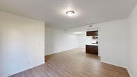 Located at 203 W Center St in Pleasant Grove, Utah, this well-appointed 2-bedroom, 2-bathroom single-floor home offers a clean, modern aesthetic throughout. The open-concept living room greets you with warm wood-look flooring, a front entry door, and a sliding glass door that fills the space with natural light and outdoor access. The kitchen is a standout feature, boasting rich dark-brown cabinetry, white countertops, a peninsula with a single-basin sink, and stainless steel appliances including a range, microwave, and refrigerator. A skylight overhead bathes the kitchen in abundant natural light, enhancing the bright and airy atmosphere. The primary bedroom is a comfortable, well-sized retreat featuring plush carpeting, a window with outdoor views, and direct access to a full bathroom with a soaking tub, vanity with white countertop, and a walk-in closet. The second bedroom also features soft carpeting and a window overlooking the greenery outside. A second bathroom serves guests and additional occupants. Wood-look flooring flows through the main living areas, while carpet adds warmth to the bedrooms. The overall design is clean and neutral, offering a versatile canvas throughout.