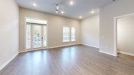 Located at 1001 W Rosedale St in Fort Worth, TX, this modern two-story home offers 2 bedrooms, 3 bathrooms, and a well-designed layout spread across two floors. The main level features an open-concept living, dining, and kitchen area bathed in natural light from large windows and glass French doors. The kitchen is appointed with two-tone cabinetry—white uppers and dark lower cabinets—complemented by a stone tile backsplash, stainless steel appliances, dark countertops, and a central island with a black matte faucet and sink. Pendant lighting and recessed fixtures add a polished touch throughout. The living area showcases wood-look flooring, a ceiling fan, and direct access to the outdoors. Upstairs, the spacious primary bedroom features plush carpeting, a private balcony with outdoor views, and a generously sized walk-in closet with built-in shelving. The second bedroom is equally well-appointed with soft carpeting and neutral tones. The three bathrooms include a tiled tub-and-shower combo with large-format gray tile and matte black fixtures. A dedicated laundry room houses a full-size side-by-side washer and dryer with overhead shelving, adding everyday convenience to this thoughtfully designed home.