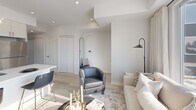 Located at 192 Erie St in Port Colborne, Ontario, this thoughtfully designed 2-bedroom, 1-bathroom unit offers a clean, modern aesthetic throughout its single-floor layout. The open-concept living and kitchen area serves as the heart of the home, featuring light hardwood-style flooring, recessed lighting, and an abundance of natural light streaming through large windows. The contemporary kitchen is equipped with stainless steel appliances, crisp white cabinetry extending to the ceiling, and a central island with a quartz countertop and breakfast bar seating — ideal for casual dining and entertaining. The living area is bright and welcoming, with oversized windows that frame outdoor views and create an airy, comfortable atmosphere. The primary bedroom is a serene retreat with a large window, plush carpeting, and a generous closet. The second bedroom features a built-in wall shelf, a sliding closet, and its own window, offering a cozy and functional space. The bathroom is finished with elegant marble-style tile surrounding a full soaker tub, complemented by clean white fixtures. Throughout the unit, the neutral colour palette, modern trim, and consistent finishes contribute to a cohesive and polished interior.