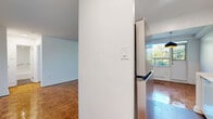 Located at 1835 Bayview Avenue in Toronto's desirable Leaside neighbourhood, this one-bedroom, one-bathroom unit offers a well-proportioned and functional layout across a single floor. Throughout the living and bedroom areas, warm-toned parquet flooring adds a classic character that complements the clean white walls and neutral palette of the space.

The living room is generously sized and bathed in natural light through a wide, multi-pane window that frames a lush, tree-lined outdoor view. A radiator beneath the window provides traditional heating, and the open, airy atmosphere makes the room feel welcoming and spacious. The layout from the doll's-eye view reveals a connected kitchen area, providing a practical flow between living and cooking spaces.

The bedroom is a comfortable, well-defined room featuring the same parquet flooring, a double-door closet, and a window that offers pleasant greenery views. It is a calm and private retreat within the unit.

The bathroom is neatly finished with warm-toned floor tiles, white subway tile surrounding a full soaker tub and shower combination, and clean white fixtures throughout, giving it a timeless and tidy appearance.

Overall, this unit offers a bright, classic interior with consistent finishes, practical room proportions, and appealing natural views — all within a sought-after Toronto location.