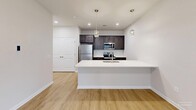 Located at 2895 Easton Ave in Bethlehem, PA, this well-designed two-bedroom, two-bathroom residence offers a thoughtful single-floor layout with contemporary finishes throughout. Light wood-style flooring runs seamlessly across the entire space, lending warmth and visual continuity to every room.

The open-concept kitchen and living area serves as the heart of the home. The kitchen features dark espresso cabinetry, a full suite of stainless steel appliances including a refrigerator, electric range, and built-in microwave, complemented by a crisp white quartz countertop peninsula with an undermount sink. Stylish pendant lighting above the peninsula adds an elegant focal point.

The spacious primary bedroom offers a comfortable retreat, with natural light streaming in through a window fitted with blinds and a ceiling fan providing year-round comfort. The second bedroom is equally bright, also featuring a window with blinds and warm neutral tones throughout.

Both bathrooms are finished with dark wood vanities, white quartz countertops, and brushed nickel fixtures. One bathroom includes a full tub/shower combination with clean white surround panels. A dedicated closet provides additional storage. The overall ambiance is clean, modern, and move-in ready, ideal for those seeking a comfortable home in the Bethlehem area.