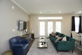 This single-floor residence offers a thoughtfully designed layout that balances functionality and style across its living spaces. The kitchen is a standout feature, showcasing white shaker-style cabinetry with dark hardware, a classic subway tile backsplash, dark countertops, stainless steel appliances, and a central island with a light-colored countertop topped by glass pendant lighting — ideal for both cooking and casual dining. Hardwood-style flooring flows throughout the main living areas, adding warmth and continuity.

The primary bedroom is generously proportioned, featuring a ceiling fan, natural light from large windows with decorative curtains, and direct access to a sleek en-suite bathroom. The primary bath is finished with a double-sink white vanity, white countertops, large-format tile flooring, and a glass-enclosed walk-in shower with tile surround. A well-organized walk-in closet with wire shelving provides ample storage.

A secondary bedroom is equally comfortable, also featuring a ceiling fan and natural light, with an adjacent bathroom offering similar high-quality finishes. A dedicated home office provides a quiet retreat, complete with hardwood-style flooring, built-in open shelving, and a cozy reading nook. Crown molding and neutral wall tones contribute to the space's clean, refined aesthetic throughout.