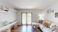 This well-appointed two-bedroom, two-bathroom residence in Columbus, Ohio offers a practical and comfortable single-floor layout. The living room serves as the heart of the home, featuring wood-look flooring, a textured ceiling, and sliding glass doors with vertical blinds that fill the space with natural light and provide outdoor views. A built-in wall shelf adds a functional architectural detail to the room.

The kitchen is designed for efficiency, featuring warm wood cabinetry, light countertops, a double-basin sink, and white appliances. It opens to a breakfast bar with barstool seating, seamlessly connecting to the rest of the living areas. Adjacent to the kitchen, the dedicated dining room is illuminated by a hanging chandelier and offers ample space for a full dining set.

The primary bedroom is generously sized and includes carpeted flooring, a walk-in closet with wire shelving systems offering plenty of organized storage, and direct access to one of the two bathrooms. The second bedroom also features carpet and a window providing natural light. Both bathrooms include tub-shower combinations with clean, white finishes.

A central hallway connects all areas of the unit, and two closets throughout the space provide additional storage. The neutral color palette and consistent wood-look flooring in the main areas create a cohesive, move-in-ready aesthetic throughout.