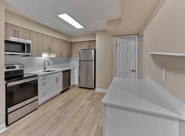 This beautifully updated kitchen, shown at our sister community Woods Edge, highlights the same sleek finishes coming soon to North Crossing Apartments — including stainless steel appliances, quartz countertops, and designer cabinetry. - North Crossing