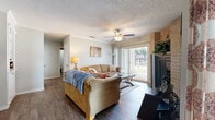 Located at 1983 Oakwell Farms Parkway in San Antonio, Texas, this well-appointed 2-bedroom, 2-bathroom single-story residence offers a comfortable and functional layout across a thoughtfully designed floor plan. Wood-look flooring flows throughout, lending a cohesive and warm aesthetic to each room.

The living room serves as the heart of the home, anchored by a striking brick fireplace and a ceiling fan overhead. Sliding glass doors fill the space with natural light and open to a private balcony overlooking lush, tree-lined grounds. Adjacent to the living area, the dedicated dining room features crown molding, a pendant light fixture, and a window that brings in additional natural light.

The galley-style kitchen is outfitted with white cabinetry, granite-look countertops, stainless steel appliances including a refrigerator and dishwasher, and direct sight lines into the dining room.

The spacious primary bedroom accommodates a large bed comfortably and includes a mirrored closet and ceiling fan. The second bedroom is equally well-sized. Both bathrooms are finished with vanities featuring stone-look countertops and wood-look flooring. A dedicated laundry area with a full-size washer adds everyday convenience. The private balcony completes this inviting home with peaceful outdoor views.