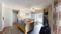 Located at 1983 Oakwell Farms Parkway in San Antonio, Texas, this well-appointed 2-bedroom, 2-bathroom single-story residence offers a comfortable and functional layout across a thoughtfully designed floor plan. Wood-look flooring flows throughout, lending a cohesive and warm aesthetic to each room.

The living room serves as the heart of the home, anchored by a striking brick fireplace and a ceiling fan overhead. Sliding glass doors fill the space with natural light and open to a private balcony overlooking lush, tree-lined grounds. Adjacent to the living area, the dedicated dining room features crown molding, a pendant light fixture, and a window that brings in additional natural light.

The galley-style kitchen is outfitted with white cabinetry, granite-look countertops, stainless steel appliances including a refrigerator and dishwasher, and direct sight lines into the dining room.

The spacious primary bedroom accommodates a large bed comfortably and includes a mirrored closet and ceiling fan. The second bedroom is equally well-sized. Both bathrooms are finished with vanities featuring stone-look countertops and wood-look flooring. A dedicated laundry area with a full-size washer adds everyday convenience. The private balcony completes this inviting home with peaceful outdoor views.