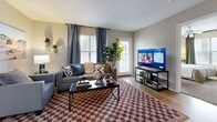 Located at 601 Luther St W in College Station, TX, this single-story unit offers 1,130 square feet of living space across 5 bedrooms, 4 bathrooms, a combined kitchen and living room, and a dedicated laundry area. The open-concept living room features wood-look flooring, large windows with natural light, and a glass door providing outdoor access. The galley-style kitchen is equipped with stainless steel appliances, a microwave, electric range, refrigerator, granite-style countertops, and white cabinetry. A peninsula with bar seating connects the kitchen to the entry and dining area. The five bedrooms are carpeted and include sliding mirrored or standard closets; the primary bedroom measures 130 square feet. Multiple bedrooms feature large windows with exterior views and ample space for study areas. The four bathrooms include granite-style vanity countertops, wood-look flooring, and shower-tub combinations. Neutral-toned walls throughout create a cohesive, versatile aesthetic. The layout is well-suited for shared living, making it an ideal option for students or young professionals near Texas A&M University.