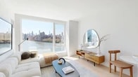 Located at 20 Hallets Point in Astoria, Queens, this thoughtfully designed 2-bedroom, 1-bathroom residence offers a bright, modern living experience with sweeping views of the East River and the Manhattan skyline. Light oak hardwood floors and crisp white walls flow throughout, creating a clean, cohesive aesthetic from room to room.

The open-concept living area is anchored by large floor-to-ceiling windows that flood the space with natural light and frame breathtaking waterfront views. The kitchen features a sleek white waterfall-edge island with bar seating, warm wood cabinetry, white upper cabinets, marble-style backsplash, and stainless steel appliances — a refined yet functional space ideal for everyday living and entertaining.

Both bedrooms are well-proportioned and bright, each benefiting from large windows with open city and river views. The primary bedroom offers a serene retreat with light-filled windows overlooking the waterfront. The bathroom is finished with neutral stone-look tile flooring, a floating wood vanity, and a backlit mirror, lending a spa-like quality to the space.

The residence also includes a dedicated closet for storage. Recessed lighting throughout and a consistent use of warm wood tones paired with white surfaces give this home a polished, contemporary feel ideal for urban living.