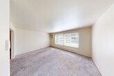 Located at 7300 Central Ave in Westland, Michigan, this 2-bedroom, 1-bathroom unit offers a functional and well-organized single-floor layout. The living room is generously sized, featuring soft carpet flooring, a wall-mounted air conditioning unit, and a wide multi-pane window that draws in natural light and provides outdoor views of the surrounding greenery. Baseboard heating runs throughout, ensuring year-round comfort. The adjacent dining area connects seamlessly to the galley-style kitchen, which is outfitted with white cabinetry, light tile flooring, a full suite of white appliances including a refrigerator and range, a built-in sink, and a convenient breakfast bar. A chandelier overhead adds a touch of warmth to the dining space. Both bedrooms are carpeted and finished in neutral tones, each featuring large sliding-door closets and windows with blinds that allow for natural light while maintaining privacy. The full bathroom includes tile flooring, a glass-enclosed shower stall, a toilet, and a single vanity with an integrated sink and mirror. With five closets spread throughout the unit, storage is plentiful. The overall aesthetic is clean, bright, and move-in ready.