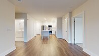 Located at 857A Federal Rd in Brookfield, CT, this well-appointed 2-bedroom, 2-bathroom residence offers a thoughtfully designed single-floor layout with a clean, modern aesthetic throughout. The open-concept living and kitchen area serves as the heart of the home, featuring warm hardwood-style flooring, recessed lighting, and a central island with a crisp white countertop. The kitchen is equipped with stainless steel appliances — including a refrigerator, range, and built-in microwave — complemented by white shaker cabinetry that extends to the ceiling for ample storage. The living room is bright and airy, highlighted by French doors that open onto a private balcony with views of the surrounding Brookfield community. Both bedrooms are carpeted for comfort, with the spacious primary bedroom offering generous dimensions and access to a well-organized walk-in closet fitted with wire shelving. The primary bathroom features a dual-sink vanity with white cabinetry, brushed nickel fixtures, a walk-in shower, and a classic black-and-white mosaic tile floor. The second bedroom benefits from a large window that fills the room with natural light. Two dedicated closets ensure practical storage throughout this move-in-ready residence.