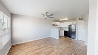 Located at 4700 Walden Cir in Orlando, FL, this single-floor unit offers a clean, functional layout designed for comfortable living. The open-concept living area is finished with warm wood-look flooring and neutral gray walls, creating a bright and versatile space. A ceiling fan overhead adds both style and practicality. The kitchen flows seamlessly from the living area and features white shaker-style cabinetry, light countertops, a peninsula breakfast bar, and black appliances including a refrigerator, electric range, and dishwasher — all set on matching wood-look flooring. The bathroom is finished with a white vanity topped with a speckled countertop, chrome fixtures, a towel bar, and a full tub-shower combination with tiled surround. The bedrooms offer a change in texture with plush carpeting underfoot, ample natural light from windows fitted with blinds, and closet storage with louvered doors. One bedroom features its own ceiling fan and an outdoor view of a grassy common area, while another offers a water view. The unit's straightforward, well-maintained design makes it a practical and comfortable home in the Orlando area.