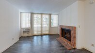 Located at 4230 S Centinela Ave in the Mar Vista neighborhood of Los Angeles, this single-floor, 2-bedroom, 2-bathroom home offers a practical and comfortable layout. The living room serves as the focal point of the home, featuring a classic brick fireplace, dark hardwood-style flooring, and large windows with vertical blinds that fill the space with natural light and offer views of lush greenery outside. The kitchen is efficiently designed with light-toned cabinetry, granite-style countertops, a gas range, and a refrigerator. A peninsula breakfast bar with seating for two opens toward the dining area, which is accented by a chandelier overhead. The primary bedroom is a well-sized retreat with hardwood-style flooring and a mirrored closet, with direct access to a full bathroom featuring a large vanity, wide mirror, and a shower-tub combination. The second bedroom also features hardwood-style flooring and a large window overlooking greenery, providing a bright and airy feel. The second bathroom includes a shower-tub combo with sliding glass doors, tile flooring, and a frosted window for natural light. A hallway connects the main areas of the home, completing this well-organized single-level floor plan.