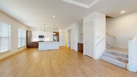 Located in Woodstock, GA, this well-appointed three-story home offers 4 bedrooms, 5 bathrooms, and an attached garage spread across three thoughtfully designed floors. The main living level serves as the heart of the home, showcasing an open-concept kitchen and living area with warm hardwood-style flooring. The kitchen is a standout, featuring a large center island with a gold-finish faucet, quartz countertops, white cabinetry contrasted by rich wood upper cabinets, a subway tile backsplash, stainless steel appliances, and stylish pendant lighting. Large windows bring in abundant natural light, enhancing the bright, airy atmosphere. The bathrooms are finished with clean, modern fixtures, including a glass-enclosed walk-in shower in one and a full soaking tub with shower combo in another, all with light wood-tone flooring. The bedrooms are carpeted for comfort, with several featuring walk-in closets outfitted with wire shelving systems and ceiling fans. The spacious primary bedroom includes a tray ceiling and generous walk-in closet. The ground-floor garage provides interior access and ample storage space. With a neutral palette and contemporary design throughout, this home delivers a clean, move-in-ready aesthetic.