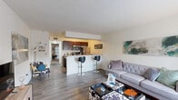 Located at 6285 Ivywood Dr in Portage, Michigan, this 1-bedroom, 1-bathroom unit offers a thoughtfully designed single-floor layout that maximizes every square foot. The open-concept living area greets you with warm hardwood-style flooring, large windows that invite natural light, and neutral walls that create a bright and welcoming atmosphere. The living room provides generous space for comfortable seating arrangements and media setup, flowing seamlessly into the kitchen and dining area.

The kitchen features rich dark wood cabinetry, stainless steel appliances including a microwave, electric range, and refrigerator, complemented by light stone countertops. A raised breakfast bar with bar seating serves as both a functional dining area and a natural divider between the kitchen and living space.

The bedroom is a well-proportioned retreat highlighted by a bold accent wall, plush carpeting, and a sliding glass door with vertical blinds that allows ample natural light and outdoor access. A hallway connecting the bedroom to the rest of the unit provides closet storage and leads to the full bathroom, which includes a tub-shower combination, dark wood vanity, and hardwood-style flooring.