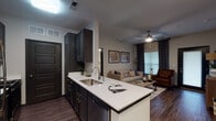 Located at 406 Noel Ln in Smyrna, Tennessee, this single-story residence offers a thoughtfully designed open-concept floor plan that seamlessly connects the kitchen, dining, and living areas. The kitchen is a standout feature, showcasing dark espresso cabinetry with brushed nickel hardware, crisp white quartz countertops, a peninsula with an undermount sink, and stainless steel appliances including a full-size refrigerator. Rich hardwood-style flooring flows throughout the main living areas, creating a cohesive and contemporary aesthetic.

The living room provides a comfortable gathering space with ceiling fan, large windows dressed with layered patterned drapes, and direct access to an exterior door. A dedicated dining area is accessible directly from the kitchen, adding functional separation within the open layout.

The bedrooms are carpeted for comfort and each features ceiling fans, generous closet space, and windows allowing natural light. The primary bedroom connects to an en-suite bathroom and includes ample room for furnishings. Additional bathrooms are finished with dark vanity cabinetry, white quartz countertops, wood-look tile flooring, and a tub-shower combination, maintaining consistent design throughout. The overall ambiance is modern and inviting with a neutral color palette.