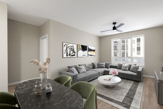 Modern Living Space with Gray Sofa, Neutral Tones, and Dining Area in Foreground - Hensley at The District