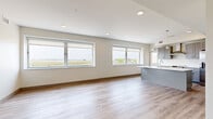 This well-appointed two-bedroom, two-bathroom residence at 21200 Brookpark Rd in Cleveland, Ohio offers a thoughtfully designed single-floor layout with a clean, modern aesthetic throughout. Light wood-look flooring runs continuously across all living areas, creating a cohesive and bright interior.

The kitchen is a functional centerpiece, featuring gray shaker-style cabinetry, white quartz countertops, stainless steel appliances including a range and dishwasher, a built-in microwave, and a deep undermount sink. A pendant light and recessed lighting illuminate the space, while a large window frames sweeping open views beyond.

The open living room extends from the kitchen and is filled with natural light from multiple large windows, each offering expansive outdoor views. The layout flows efficiently into a hallway connecting the bedrooms and bathrooms.

The spacious primary bedroom includes direct access to a private en-suite bathroom equipped with blue-gray vanity cabinetry, a lighted mirror, and a walk-in closet with wire shelving. A second bedroom also features a large window with open views. The second bathroom offers a glass-enclosed walk-in shower with brushed nickel fixtures, while the primary bath includes a full soaking tub with textured white surround. The overall design is neutral, modern, and move-in ready.