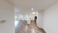 Located at 4415 Fairmount Ave in San Diego, California, this single-floor residence offers a clean, modern aesthetic throughout its thoughtfully designed layout. The open-concept living and kitchen area is anchored by warm wood-style luxury vinyl plank flooring, crisp white walls, and recessed lighting that creates a bright, welcoming atmosphere. Large sliding glass doors and vertical blinds in the living area allow generous natural light to filter in while providing views of surrounding greenery.

The kitchen is a standout feature, showcasing white shaker-style cabinetry with ample storage, sleek quartz countertops, a peninsula with an undermount sink, and a full suite of stainless steel appliances including a refrigerator, range, and over-the-range microwave. The peninsula serves as a functional divider between the kitchen and the open living space, ideal for casual dining or entertaining.

The bedroom is carpeted for comfort and features a window dressed with vertical blinds, offering a quiet, softly lit retreat. An additional room with wood-style flooring provides flexible living space with direct outdoor access. The bathroom is finished in a clean white palette, complete with a vanity, mirror, and a full shower-tub combination, rounding out this well-appointed San Diego residence.