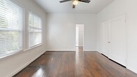 Located on N Kingsley Drive in the desirable Los Feliz neighborhood of Los Angeles, this single-floor unit offers a practical and well-organized layout across its rooms. Rich, dark hardwood floors run throughout the main living areas, adding warmth and character to the space.

The living room is bright and airy, featuring multiple windows fitted with white blinds that allow generous natural light to fill the room. A ceiling fan overhead provides year-round comfort. Clean white walls keep the space feeling open and fresh.

The layout flows into a combined dining and kitchen area, where the flooring transitions to light ceramic tile. The kitchen is equipped with white cabinetry, a dark countertop with an undermount sink, a gas range, and a full-size refrigerator — providing all the essential appliances for daily use.

The bathroom is finished in a clean all-white palette, including a vanity with under-sink storage, a wall-mounted mirror with overhead lighting, a toilet, and a full bathtub with shower. Light tile flooring completes the look.

Two closets offer practical storage solutions. A small hallway area with a wall-mounted mirror adds a functional transitional space between rooms. The unit's straightforward design and classic finishes make it a functional home in a well-connected Los Angeles neighborhood.