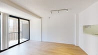 Located at 1133 N Dearborn Street in Chicago's prestigious Gold Coast neighborhood, this thoughtfully designed single-floor unit offers a clean, modern aesthetic throughout. The open-concept living area is anchored by light hardwood flooring and crisp white walls, creating a bright and airy atmosphere. Track lighting adds a contemporary touch, while a large sliding glass door leads to a private balcony, inviting abundant natural light and outdoor views into the living space. A pass-through window connects the living area to the kitchen, enhancing the open feel between rooms. The galley-style kitchen is well-appointed with white shaker cabinetry, marble-style countertops, a stainless steel sink, and a full suite of stainless steel appliances, including a refrigerator, range, microwave, and dishwasher. Light hardwood-style flooring continues throughout, tying the spaces together cohesively. The bathroom features classic black-and-white mosaic tile flooring, a dark wood vanity with a white countertop, a mirrored medicine cabinet, a full bathtub and shower combination, and brushed nickel fixtures and lighting. The overall design of the unit is clean and minimalist, making it a functional and stylish space in one of Chicago's most sought-after neighborhoods.