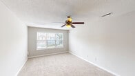 Located at 709 Patriot Pkwy in Rock Hill, SC, this single-floor residence offers a practical and comfortable layout with two bedrooms and two full bathrooms. The galley-style kitchen is well-appointed with white shaker cabinetry, granite countertops, a subway tile backsplash, black appliances including a range and refrigerator, a double stainless steel sink, and rich hardwood-style flooring that extends into the bathrooms. A peninsula counter provides a convenient transition between the kitchen and the adjoining living area. Both bedrooms are carpeted and finished in neutral tones, with ceiling fans for added comfort. The primary bedroom is generously sized and includes a closet, while the secondary bedroom features a large window that brings in natural light and views of the surrounding neighborhood. Each bathroom is equipped with a soaking tub and shower combination, granite-topped vanities, and hardwood-style flooring. A dedicated utility room and additional closet provide practical storage solutions. The textured ceilings and clean, neutral color palette throughout lend the space a cohesive and move-in-ready feel.