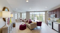 This single-floor residence is thoughtfully designed with a neutral warm palette, light wood-style flooring, and recessed lighting that flows consistently throughout each room. The spacious living area serves as the heart of the home, featuring large floor-to-ceiling windows with vertical blinds that invite abundant natural light and provide views of mature landscaping outside. The open layout connects seamlessly to a well-appointed kitchen outfitted with rich dark wood cabinetry extending to the ceiling, white quartz countertops, a full suite of stainless steel appliances including a range, dishwasher, microwave, and refrigerator with ice maker.

A versatile den or secondary living space offers built-in closet storage and is highlighted by bold contemporary artwork, providing a functional retreat. The primary bedroom is generously sized with large windows, recessed lighting, and direct access to a private bathroom featuring a walk-in closet, vanity with dark wood cabinetry, and light stone countertops. A second bathroom includes a tub-shower combination, backlit mirror, and matching vanity. Throughout, the design maintains a cohesive, modern residential aesthetic with practical and comfortable living spaces.