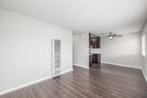 Located at 1648 Del Amo Blvd in Torrance/Los Angeles, CA, this two-bedroom, one-bathroom unit offers a thoughtfully designed single-floor layout. Wood-look laminate flooring runs throughout, providing a cohesive and modern feel across every room. The open living area connects seamlessly to the galley-style kitchen, which is outfitted with rich dark espresso cabinetry, a white subway tile backsplash, light countertops, stainless steel appliances including a gas range and refrigerator, and a ceiling fan overhead. A wall-mounted heating unit in the living area ensures year-round comfort. The primary bedroom features mirrored sliding closet doors that enhance the sense of space and reflect natural light. A second bedroom serves as a standout with a multicolored reclaimed wood-style shiplap accent wall and a window allowing natural light to filter in. The full bathroom is finished with matching dark cabinetry, a vessel sink, light countertops, a large mirror, and a tub-shower combination. Textured ceilings are present throughout, and neutral wall tones create a clean, versatile backdrop. The layout is efficient and functional, making excellent use of every square foot available.