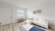 Located in Kissimmee, FL, this clean and well-appointed 2-bedroom, 1-bathroom unit offers a bright, open-concept layout across a single floor. Light wood-style flooring flows throughout the main living areas, lending a fresh and cohesive aesthetic.

The living room is a welcoming space featuring a large window that invites natural light and provides views of the surrounding greenery. A wall-mounted HVAC unit provides climate control comfort. The area flows seamlessly into a dedicated dining space with recessed lighting overhead.

The kitchen is well-equipped with crisp white shaker cabinetry, light countertops, and a full suite of stainless steel appliances including a refrigerator, dishwasher, and range. Recessed lighting brightens the workspace, and the open connection to the dining area enhances the functional layout.

The spacious primary bedroom features plush carpeting, a window overlooking outdoor greenery, and ample room to furnish comfortably. The second bedroom is equally bright, with natural light filtering through window blinds and a similar carpeted finish. The bathroom is finished with elegant marble-style tile flooring and clean white walls. A dedicated closet rounds out the unit's practical offerings.