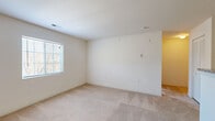 Located at 140 Bromley Village Drive in Fort Mill, SC, this one-bedroom, one-bathroom residence offers a practical and well-organized single-floor layout. The living room is a bright, open space featuring plush wall-to-wall carpeting, neutral walls, and a ceiling fan with light fixture, complemented by a window that invites natural light and outdoor views. The bedroom is a generously sized carpeted retreat with its own window fitted with blinds, providing both comfort and privacy. The kitchen is equipped with light wood cabinetry, granite-style countertops, and black appliances including a refrigerator, electric range, and built-in microwave, all set over easy-care tile flooring. The bathroom includes a full tub-shower combination, a vanity with granite-style countertops and wood cabinetry, and tile flooring that echoes the kitchen's clean aesthetic. A dedicated closet area with wire shelving and in-unit washer/dryer hookups adds valuable functionality. A hallway connects the spaces efficiently, and the overall interior palette of soft neutrals and warm tones creates a cohesive, move-in-ready atmosphere throughout.