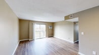 Located at 260 Oxford Dr in Winchester, Kentucky, this single-floor, 3-bedroom, 1-bathroom home offers a practical and well-organized layout. Warm neutral-toned walls and durable hardwood-style flooring flow consistently throughout, creating a cohesive and clean aesthetic across the entire home.

The living room serves as the central gathering space, featuring a sliding glass door that opens to a private balcony with outdoor views of the surrounding neighborhood, as well as a wall-mounted A/C unit and textured ceiling. It connects openly to the dining area, offering a comfortable flow for everyday living. The galley-style kitchen is outfitted with white cabinetry, a stainless steel sink with laminate countertops, and stainless steel appliances including a refrigerator and range.

The three bedrooms are each finished with the same warm flooring and neutral walls. The spacious primary bedroom includes its own closet access, while the secondary bedrooms feature large windows that bring in ample natural light and views of the outdoors. In total, the home includes five closets, providing generous storage throughout. The single bathroom is equipped with a full tub and shower combination with a clean white surround. A hallway connects the private areas of the home efficiently, completing this well-appointed and move-in ready residence.