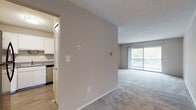 The Huron Premiere is a thoughtfully designed 1-bedroom, 1-bathroom unit spread across a single floor. The open living and dining area is finished with plush carpeting and a textured ceiling, creating a comfortable and welcoming atmosphere. A ceiling fan adds functionality, while a large sliding glass door floods the space with natural light and provides direct access to a private balcony. The balcony, framed by a classic brick exterior, offers pleasant outdoor views and additional space to relax.

The kitchen is efficiently laid out with white cabinetry, gray laminate countertops, wood-style flooring, and a stainless steel electric range with an overhead vent. A double stainless steel sink rounds out the well-equipped cooking space.

The bedroom is generously sized, featuring soft carpeting, neutral-toned walls, and its own sliding glass door leading to the balcony, bringing in ample natural light and outdoor views. A closet provides practical storage directly within the room.

The bathroom is clean and functional, featuring a tub-shower combination, a white vanity with gray countertop, a large mirror, and durable wood-style flooring. The unit's cohesive neutral palette and practical layout make it a comfortable and inviting living space.