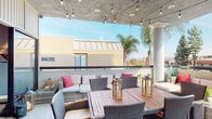 Located at 5447 White Oak Ave in Encino, California, this rooftop terrace offers a well-appointed outdoor living experience with a seamless blend of comfort and functionality. The space is defined by a partially covered concrete ceiling adorned with warm string lights, creating an inviting ambiance for both daytime relaxation and evening gatherings. Classical columns anchor the covered section, adding an architectural elegance that contrasts beautifully with the modern surroundings.

The lounge area features generously cushioned wicker sofas and chairs accented with vibrant red throw pillows, arranged around a central coffee table to encourage conversation. Adjacent to the lounge, a dedicated outdoor dining area provides ample seating for group meals, complete with a substantial teak-style dining table and wicker chairs. Decorative lanterns serve as stylish centerpieces throughout.

The terrace opens to panoramic views of the Encino skyline, neighboring palm trees, and the hillside beyond, with natural light flooding the space throughout the day. A sliding glass door connects the terrace directly to a compact, private fitness room featuring a bold orange accent wall, a stationary bike, a weight bench, dumbbells, and wall-mounted equipment — ideal for convenient daily workouts. Decorative botanical artwork and thoughtful detailing throughout the terrace complete the polished, resort-like atmosphere.