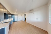 This well-appointed one-bedroom, one-bathroom unit is located in Sonoma, CA, and offers a thoughtfully designed single-level layout. The open-concept living, dining, and kitchen area forms the heart of the space, bathed in natural light from large windows with blinds and a glass door leading to a private balcony with outdoor views. The kitchen is a standout feature, boasting floor-to-ceiling dark espresso cabinetry, white quartz countertops, a stainless undermount sink, and white appliances including a range, dishwasher, and refrigerator. Recessed lighting and a wall-mounted mini-split HVAC unit add both function and a clean, modern aesthetic throughout the main living area. Light wood-style flooring runs consistently throughout the unit, creating a cohesive and warm feel. The bedroom is a comfortable, bright retreat with a large window overlooking greenery, a wall-mounted mini-split unit, and a spacious sliding-door closet. The hallway provides additional closet storage. The bathroom is clean and modern, featuring a full soaking tub with subway tile surround, a dark vanity with quartz countertop, an undermount sink, and a large mirror. This unit combines practical functionality with contemporary finishes in the heart of California's wine country.