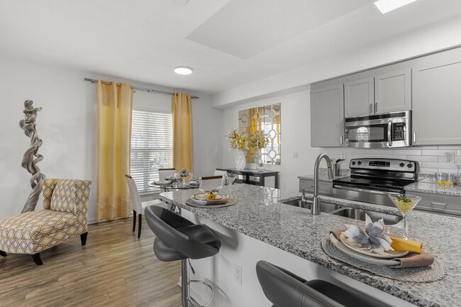 Cocina y comedor renovados con piso de tablones de vinilo de superficie dura. - Avalon Coconut Creek