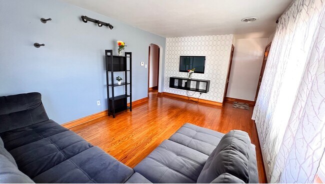 Sala de estar con sofá grande y televisor. - 324 Woodland View Dr