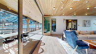 Located at 40 Mt. Eve Road in Eagle, Colorado, this contemporary mountain clubhouse is thoughtfully designed to blend indoor comfort with the dramatic natural landscape of the surrounding Rocky Mountains. The single-floor layout offers a generous and versatile gathering space anchored by a stylish living room complete with a sleek linear fireplace, plush sectional seating, hardwood flooring, and a coffered wood-paneled ceiling with designer pendant lighting and curated artwork.

Natural light floods the interior through large floor-to-ceiling sliding glass doors that open to a covered outdoor deck. The deck, supported by timber columns beneath a warm wood ceiling, features outdoor dining seating and sweeping views of snow-dusted mountain ridges and the surrounding landscape.

A dedicated conference room with a long wood table, upholstered chairs, and globe pendant lights provides a professional meeting environment. Private work pods with built-in desks, soft carpet, and mountain-facing windows offer quiet individual workspaces. The entry foyer is welcoming with tile flooring, wood-clad ceilings, stone accent walls, and bold artwork.

Outside, a lap pool enclosed by iron fencing sits against a striking backdrop of snow-covered mountains, offering a year-round resort-like amenity. The overall ambiance seamlessly merges mountain warmth with modern design.