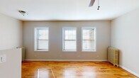Located at 1116 Washington Blvd in the vibrant neighborhood of Oak Park, Illinois, this single-floor unit offers a well-organized and comfortable layout. Warm-toned hardwood floors flow consistently throughout the living spaces, lending a cohesive and inviting character to the interior.

The main living area is notably open and bright, highlighted by a trio of double-hung windows fitted with blinds that allow for flexible light control. A ceiling fan overhead adds both function and a finishing touch to the space. A classic cast-iron radiator along one wall reflects the building's enduring construction, ensuring efficient heating. A second connected room extends the living area further, offering additional flexibility.

The kitchen is efficiently designed, featuring rich dark wood cabinetry, granite countertops with an undermount sink, and stainless steel appliances including a full-size refrigerator. Hardwood floors continue seamlessly into this space, maintaining design continuity throughout.

The bathroom is thoughtfully finished with large-format neutral tile surrounding the tub and shower, complemented by a dark wood vanity with a stone countertop, framed mirror, and chrome fixtures. A frosted window provides natural light while maintaining privacy.

Overall, this space combines classic architectural details with functional, updated finishes, creating a practical and attractive living environment in one of Chicago's most sought-after suburbs.
