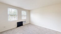 Located at 303 Holly Dr in Middle River, MD, this single-floor home offers three bedrooms, one bathroom, and four closets within a compact, efficiently laid-out floor plan. The neutral, light-toned walls and soft carpeting throughout the bedrooms and hallways create a clean, cohesive aesthetic. Each bedroom is brightened by windows with blinds, allowing natural light to filter in, and each features a classic cast-iron radiator that adds a distinctive, functional character to the rooms. The primary bedroom is the most spacious of the three, offering generous room to furnish comfortably. Two of the additional bedrooms also feature ceiling fans for added comfort. The kitchen is equipped with warm wood-toned cabinetry, granite-style countertops, a dishwasher, and a range, with easy-care wood-look flooring and a window overlooking the outdoors. The bathroom is finished with wood-look flooring, a full soaking tub with tiled surround, a window for natural light, and a cast-iron radiator consistent with the home's character. Two hallways connect the spaces efficiently, and the four closets provide practical storage throughout. The overall ambiance is clean, bright, and move-in ready.
