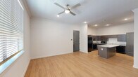 This single-story, 3-bedroom, 2-bathroom home in Lafayette, Louisiana offers a well-organized layout with modern finishes throughout. Light wood-tone flooring runs continuously across all rooms, creating a bright and cohesive aesthetic complemented by crisp white walls and crown molding.

The open-concept kitchen and living area serves as the heart of the home. The kitchen is equipped with dark espresso cabinetry, granite countertops, a central island with additional counter space, and black appliances including a refrigerator, range, microwave, and dishwasher. Recessed lighting and crown molding add a polished touch. The adjacent living area features a ceiling fan with light fixture and seamless access to the entry door.

A central hallway connects the bedrooms and bathrooms. The primary bedroom is a comfortable, well-proportioned room with a ceiling fan and natural light from a window fitted with blinds. The additional bedrooms also feature windows that bring in natural light, enhancing the airy feel of the space.

The bathrooms are finished with granite-topped dark vanities, sliding glass-enclosed walk-in showers, and matching chrome hardware. The consistent use of quality materials and a neutral color palette throughout gives this home a clean, modern character ideal for comfortable everyday living.