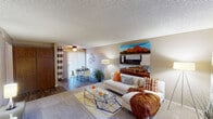 Located at 4802 N 12th St in Phoenix, Arizona, this single-floor residence offers a well-organized layout designed for comfortable everyday living. The open living area is generously sized, featuring carpet flooring, a textured ceiling, and large vertical-blind windows that allow ample natural light to fill the space. A ceiling fan adds to the comfort, while a sliding glass door leads to a private patio and a dedicated dining area. The galley-style kitchen is efficiently arranged with wood-toned cabinetry, granite-style countertops, black appliances including a range and refrigerator, a double stainless steel sink, and wood-look flooring. Two bedrooms provide comfortable retreats, each with carpet flooring, large windows with vertical blinds, textured ceilings, and open closets with shelving for organized storage. Both bathrooms follow a consistent design, featuring wood-toned vanity cabinetry, light stone countertops, expansive mirrors with overhead lighting, wood-look flooring, and a separate tub-shower combination. The overall aesthetic is warm and neutral throughout, creating a cohesive and functional living environment in a well-connected Phoenix neighborhood.