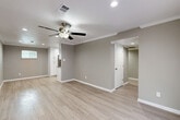 Located at 2530 Briar Ridge Dr in Houston, TX, this single-story 2-bedroom, 2-bathroom home offers a clean, modern aesthetic throughout. Light wood-style flooring flows seamlessly across the open living and dining areas, complemented by neutral gray walls, crisp white crown molding, and ceiling fans with recessed lighting in every room.

The spacious living room features French doors that invite natural light and provide access to the exterior, while the open layout connects effortlessly to the dining area. The well-equipped kitchen stands out with floor-to-ceiling white shaker cabinetry, granite countertops, stainless steel appliances, a decorative mosaic tile backsplash, and a built-in wine rack — offering both style and function.

Both bedrooms are generously sized and finished with the same light flooring and ceiling fans. The primary bedroom includes a built-in vanity area and access to a dedicated closet. The bathrooms are tastefully updated, featuring hexagonal tile flooring, marble-style tub surrounds with decorative accent tile, white cabinetry, and dark granite countertops.

A dedicated laundry room with overhead white cabinetry and patterned tile flooring accommodates a full-size washer and dryer. Two closets provide additional storage throughout the home.