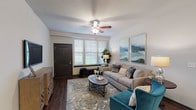 This single-story residence at Springs at LaGrange offers a cohesive, modern design with consistent finishes carried throughout each room. The living area serves as the heart of the home, featuring rich hardwood-style flooring, a ceiling fan, and multiple windows fitted with horizontal blinds that allow ample natural light to fill the space. Neutral wall tones provide a versatile backdrop for the room's comfortable layout.

The kitchen is a standout feature, showcasing dark espresso cabinetry paired with granite-style countertops and a full suite of stainless steel appliances, including a refrigerator, range, microwave, and dishwasher. A peninsula provides additional counter space and a casual dining option, while pendant lighting adds a polished touch overhead.

The bedroom is generously proportioned, offering plush carpeting, a ceiling fan, and windows with outdoor views, creating a calm and restful environment. Each bathroom mirrors the kitchen's design aesthetic, featuring dark cabinetry with granite-style countertops, a large vanity mirror, hardwood-style flooring, and a shower/tub combination. Together, the rooms present a unified and well-finished living environment.