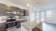 Located at 950 Town Lake Dr in College Station, TX, this single-floor unit offers a thoughtfully designed layout with contemporary finishes throughout. The kitchen serves as a focal point, showcasing dark espresso cabinetry, granite countertops, and a striking gray subway tile backsplash. A central island with pendant lighting provides additional prep space and a natural gathering area. Stainless steel appliances, including a refrigerator, range, microwave, and dishwasher, complete this well-equipped kitchen. Light wood-style flooring runs through the main living and kitchen areas, lending warmth and continuity to the open layout. Natural light filters in through multiple windows dressed with blinds, brightening the space throughout the day. The bedroom features plush carpeting, a ceiling fan, and windows offering exterior views. Closet space includes built-in shelving and a hanging rod for organized storage. The bathroom is finished with neutral tile surrounding a soaking tub and shower combo, paired with a granite-topped vanity and light wood-look flooring. Clean white walls and a neutral palette throughout create a bright, cohesive ambiance well-suited for comfortable everyday living.