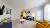 Located at 800 Hydric Ct in Odenton, Maryland, this single-floor residence offers a thoughtfully organized layout featuring two bedrooms, two bathrooms, a combined dining and kitchen area, two hallways, and a closet. The living area is carpeted and bright, featuring a textured ceiling, a fireplace, and a glass-paneled exterior door that invites natural light. The kitchen is outfitted with crisp white cabinetry, light granite-style countertops, full appliances including a range, microwave, and refrigerator, and tile flooring that complements the clean, functional design. Adjacent to the kitchen, the dining area features warm hardwood-style flooring and large windows dressed with sheer curtains, creating an airy and welcoming atmosphere. The primary bedroom is generously proportioned, featuring plush carpet and soft neutral tones that foster a restful environment. The second bedroom also offers carpeted flooring and a window with natural views. Both bathrooms are finished with tile flooring and white vanities; one features a well-lit mirror and ample counter space. Hallways connect the spaces efficiently, contributing to a smooth and practical flow throughout the home. The overall ambiance is clean, neutral, and move-in ready.